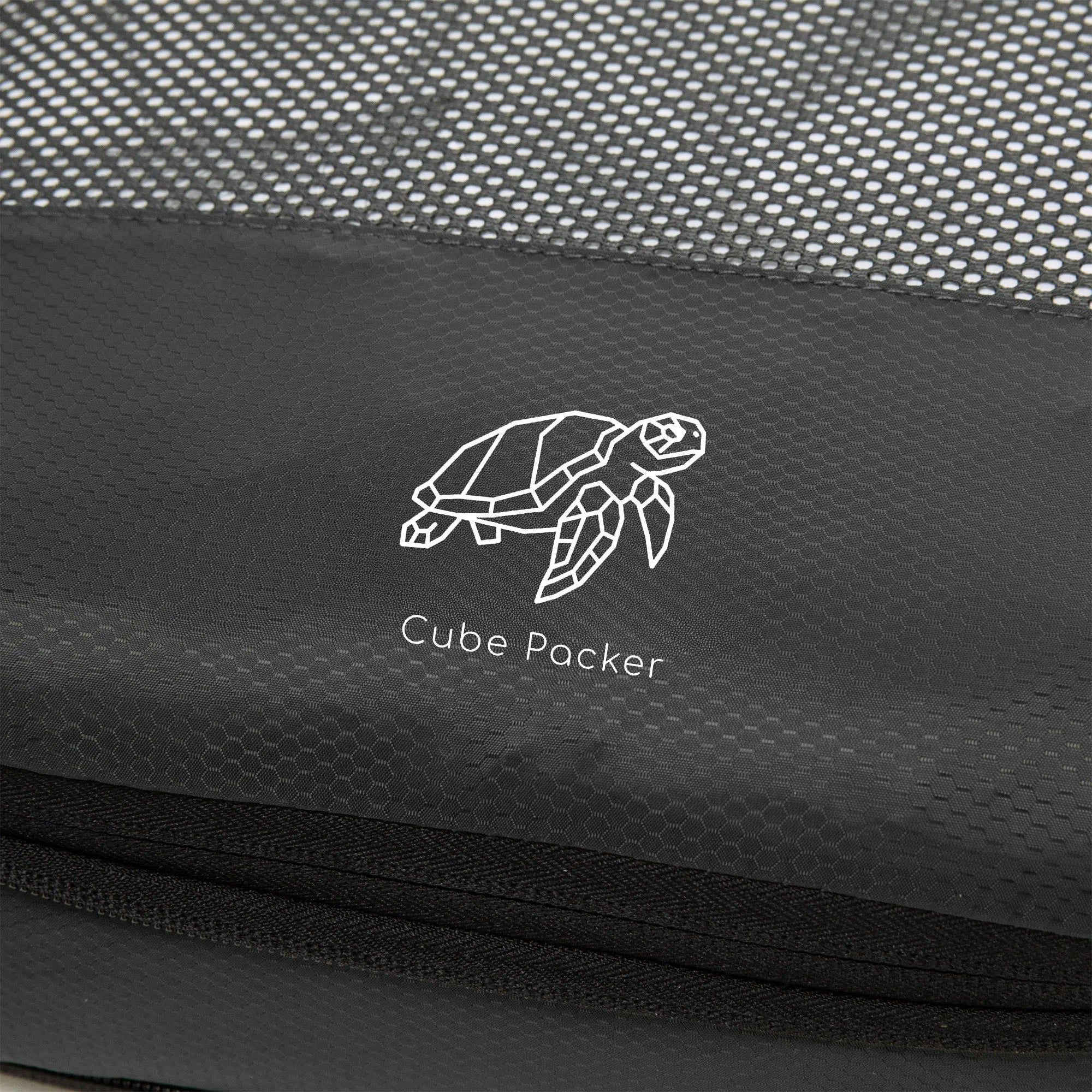 Close up of Cube Packer compression packing cube in black showing mesh fabric and logo detail