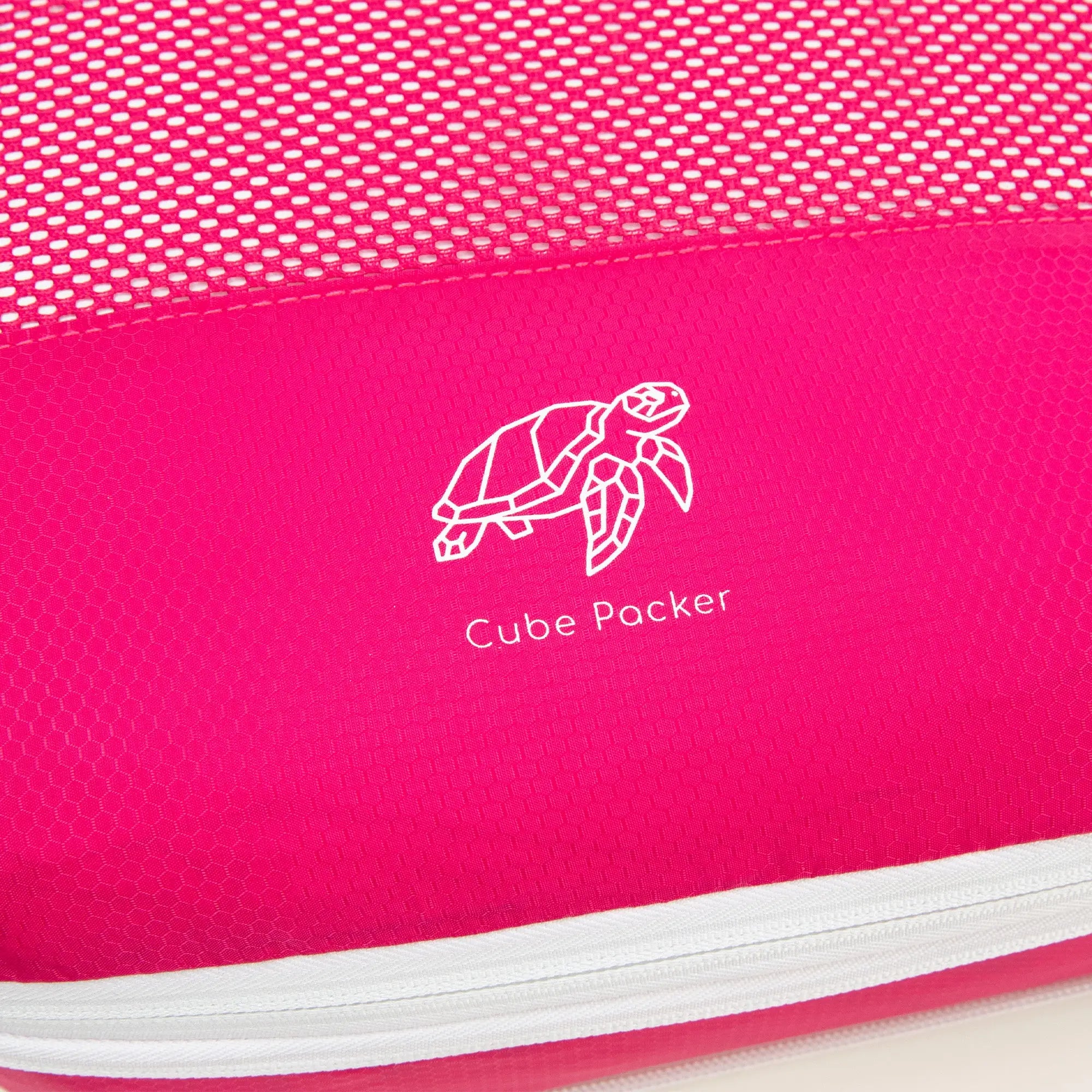 Close up of Cube Packer compression packing cube in pink showing mesh fabric and logo detail
