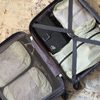 Open suitcase packed with Cube Packer compression packing cubes in cream for organised for travel