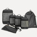Cube Packer Essential Bundle with compression packing cubes, shoe bag and laundry bag in black on a white background