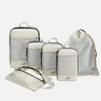 Cube Packer Essential Bundle with compression packing cubes, shoe bag and laundry bag in cream on a white background