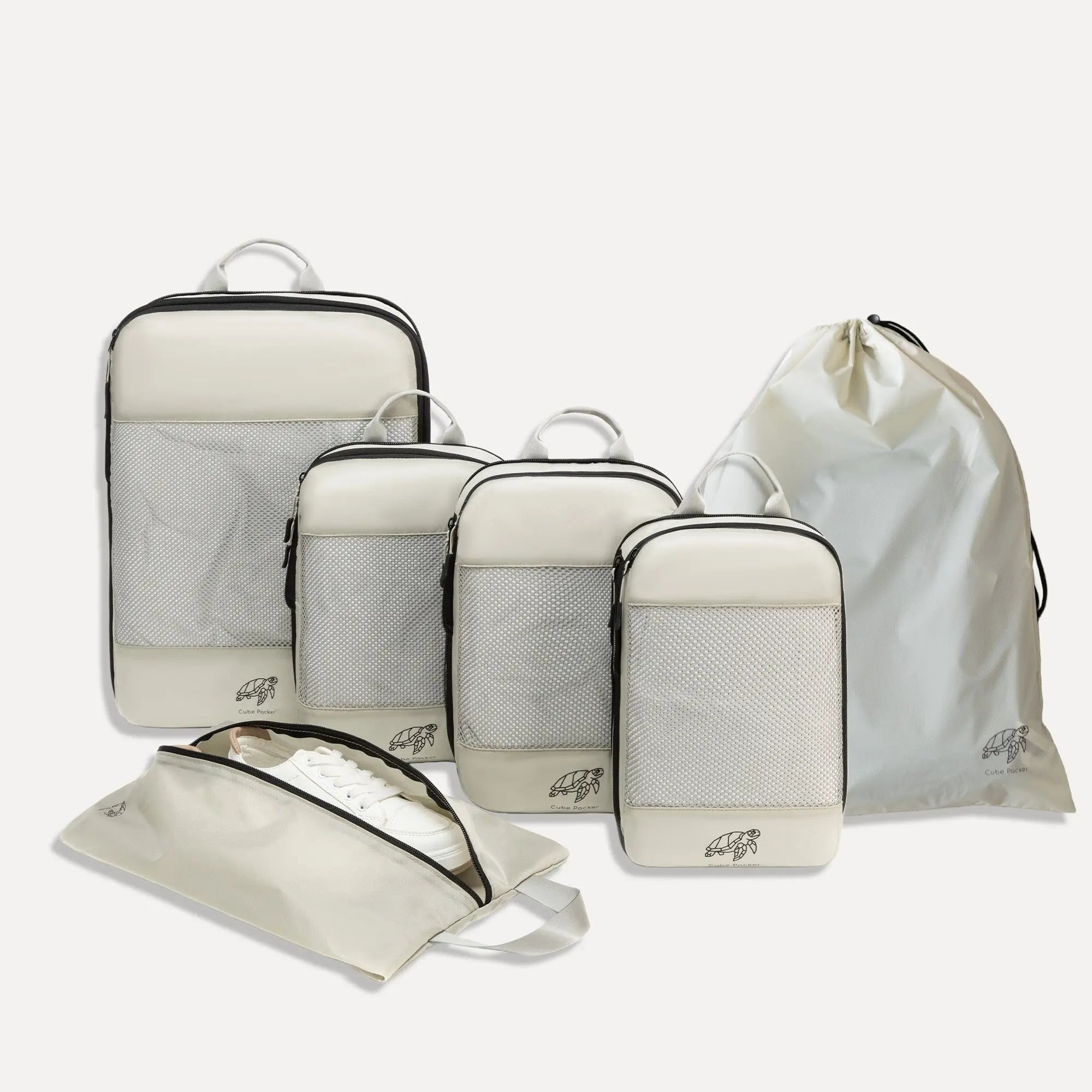 Cube Packer Essential Bundle with compression packing cubes, shoe bag and laundry bag in cream on a white background