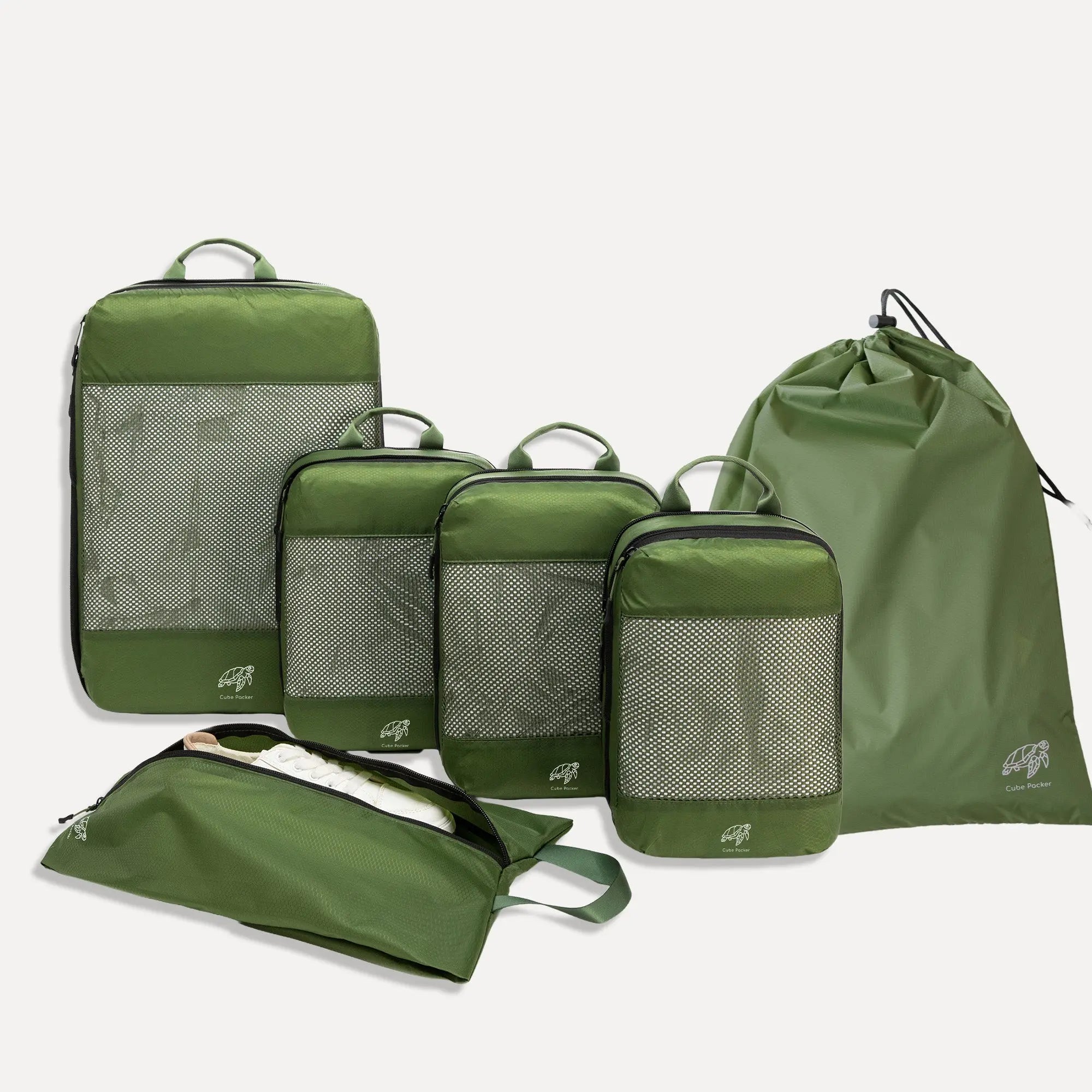 Cube Packer Essential Bundle with compression packing cubes, shoe bag and laundry bag in green on a white background
