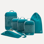 Cube Packer Essential Bundle with compression packing cubes, shoe bag and laundry bag in teal on a white background