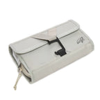 Sand roll-up wash bag folded flat and strapped, viewed from above at an angle