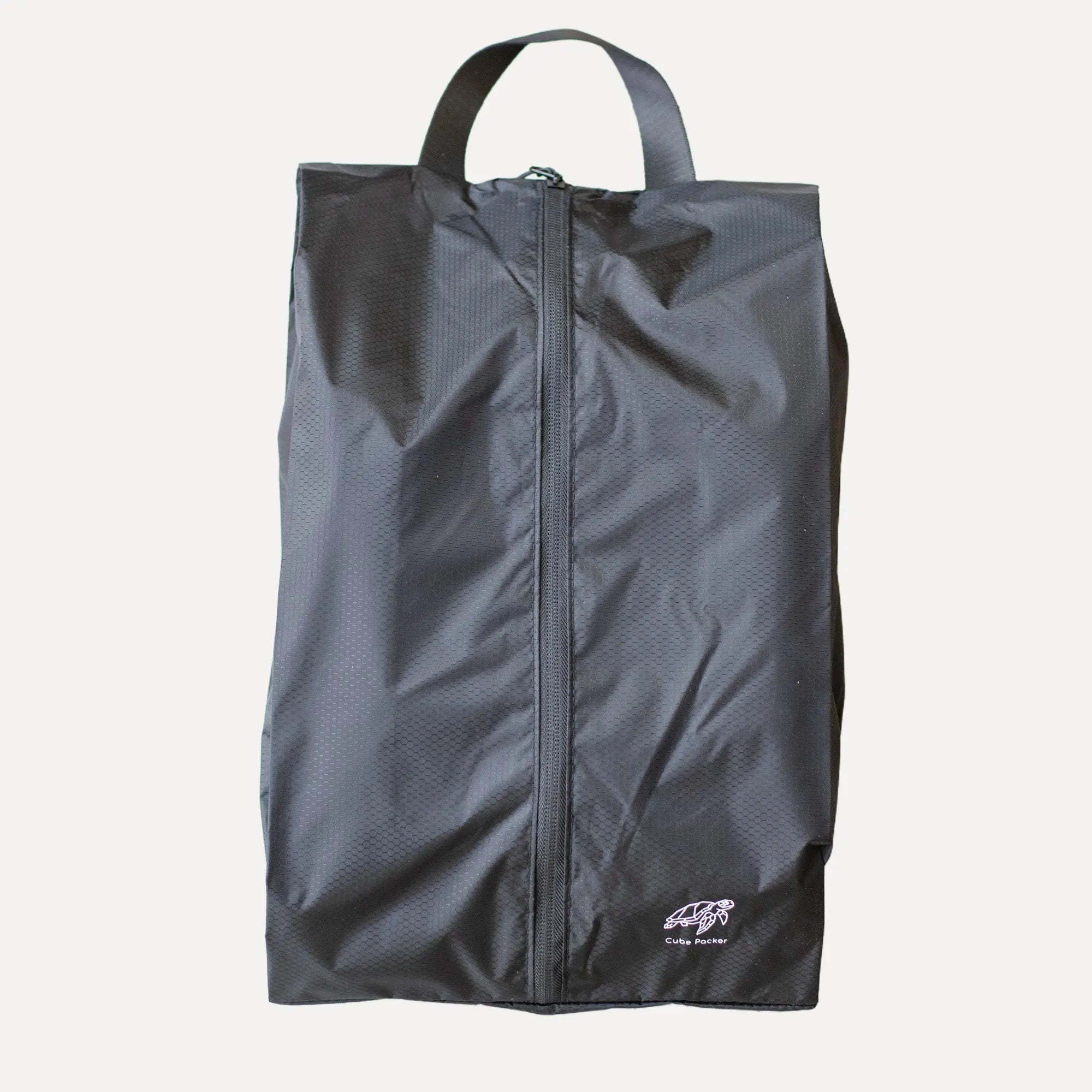 Cube Packer shoe bag in black standing upright for clean and organised travel storage