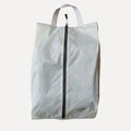 Cube Packer shoe bag in cream standing upright for clean and organised travel storage