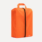 Cube Packer shoe bag in orange standing upright for clean and organised travel storage