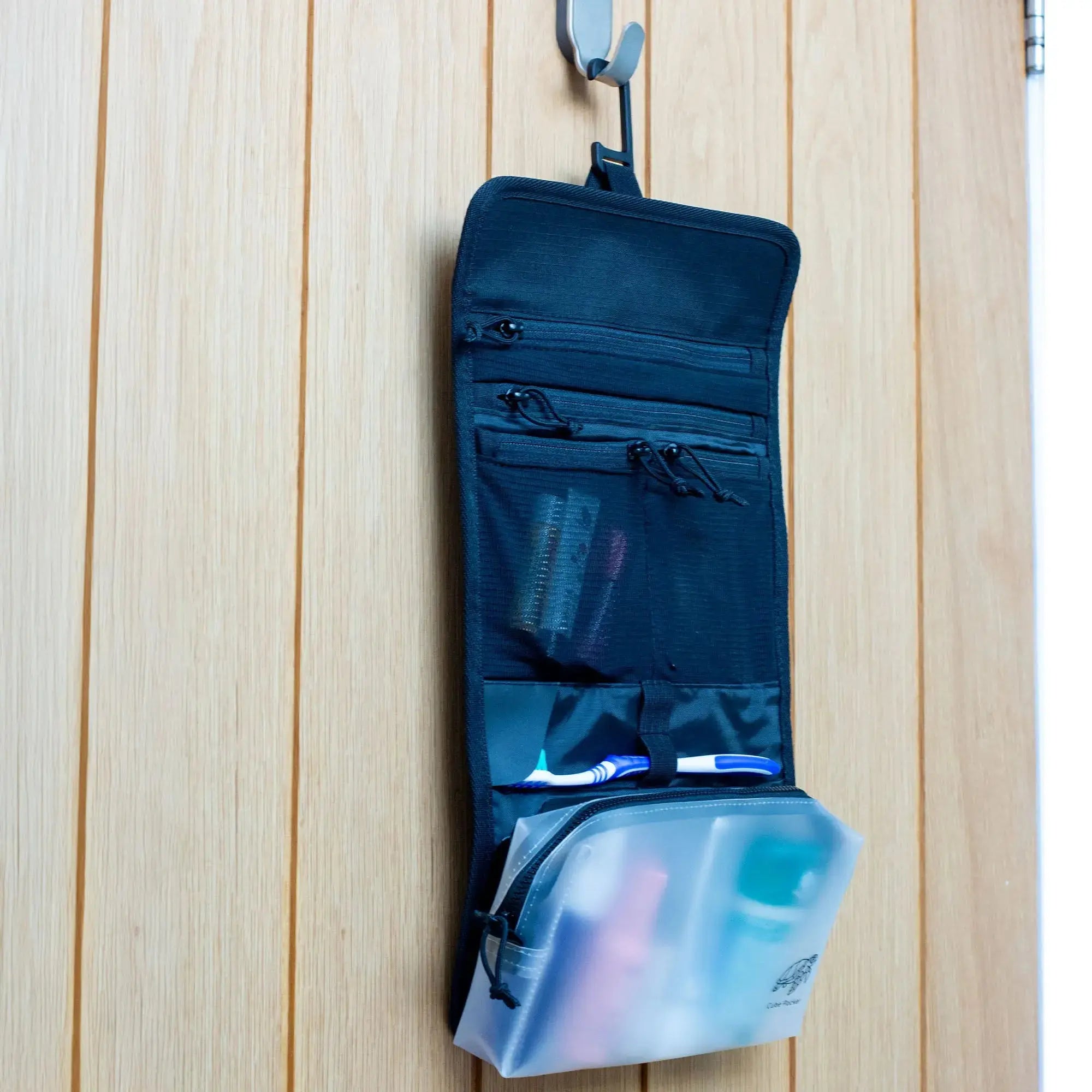 Cube Packer roll up toiletries bag hanging open on a hook with toiletries visible inside