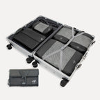 Cube Packer Travel System Bundle in Black including compression packing cubes, shoe bag, laundry bag and toiletries bag arranged inside a suitcase
