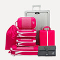 Cube Packer Travel System Bundle in Pink including compression packing cubes, shoe bag, laundry bag and toiletries bag arranged in front of a suitcase
