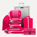 Cube Packer Travel System Bundle in Pink including compression packing cubes, shoe bag, laundry bag and toiletries bag arranged in front of a suitcase