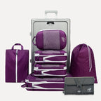 Cube Packer Travel System Bundle in Purple including compression packing cubes, shoe bag, laundry bag and toiletries bag arranged in front of a suitcase
