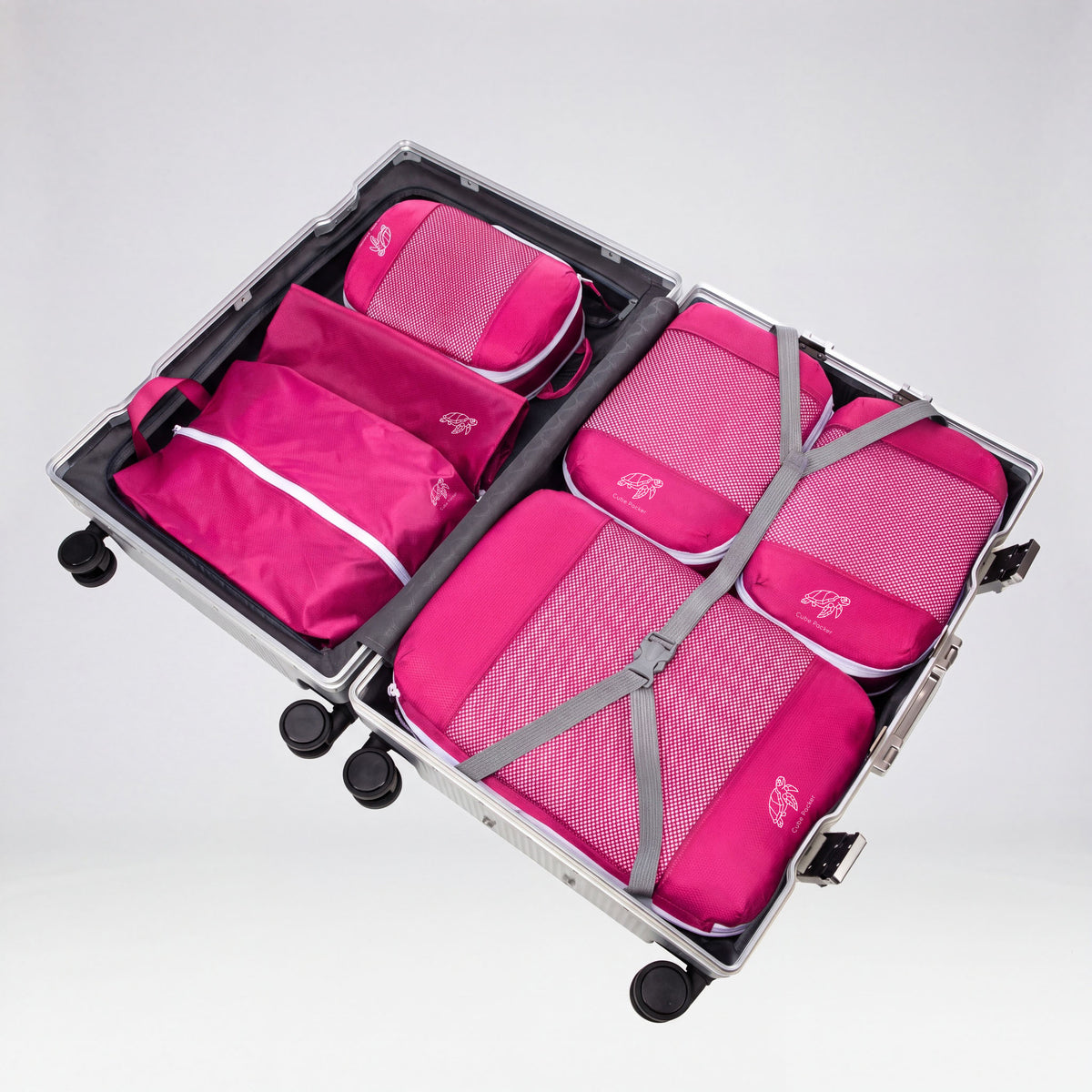 Flamingo Pink Cube Packer Essential Packing Bundle packed inside an open aluminium suitcase