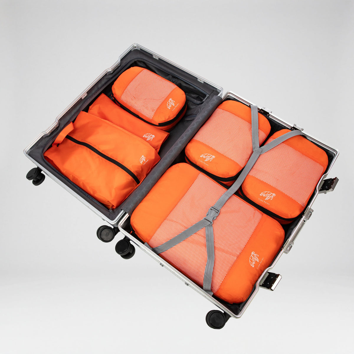 Nemo Orange Cube Packer Essential Packing Bundle packed inside an open aluminium suitcase